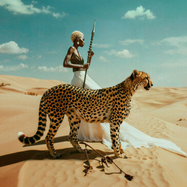 Beautiful African woman in desert with cheetah