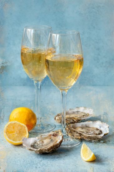Stijlvolle still life wanddecoratie met champagneglazen, oesters en citroen in zachte blauwe tinten