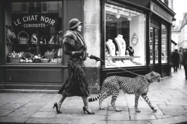 Zwart-wit wanddecoratie van elegante vrouw die een cheeta uitlaat in vintage Parijse straat